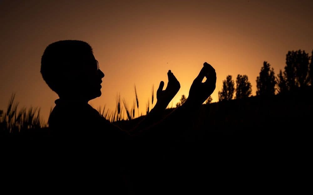 A traveller checking prayer times on a phone at an airport gate